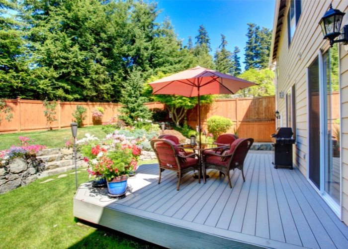 Landscaping tips to increase property value blog - picture of backyard with deck, fence & gardens
